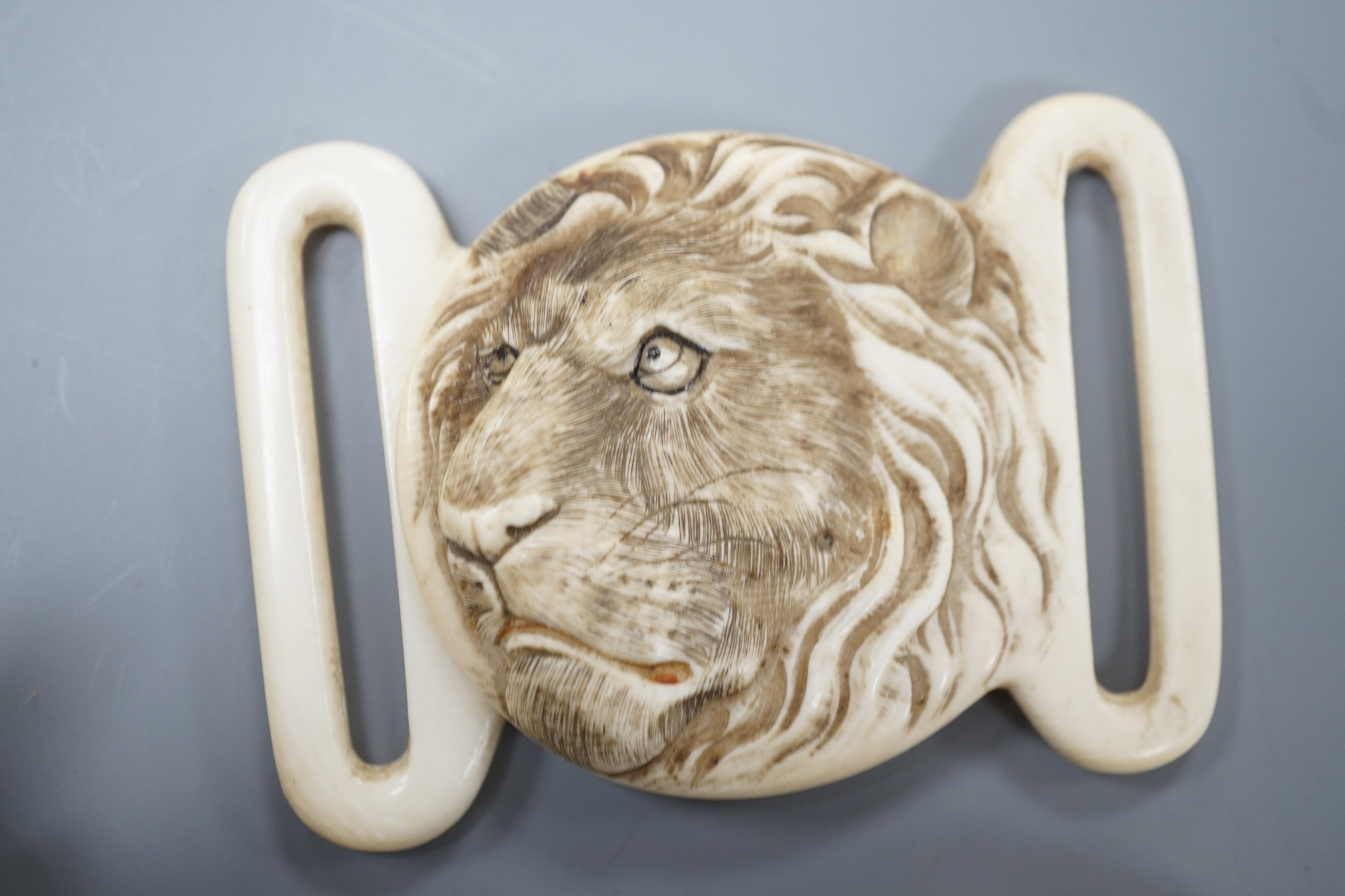 Two Japanese lacquer boxes, an ivory and bronze manju, an ivory ‘lion’ two-piece belt buckle and two simulated ivory items, late 19th/early 20th century, largest Box 11.5 cm
